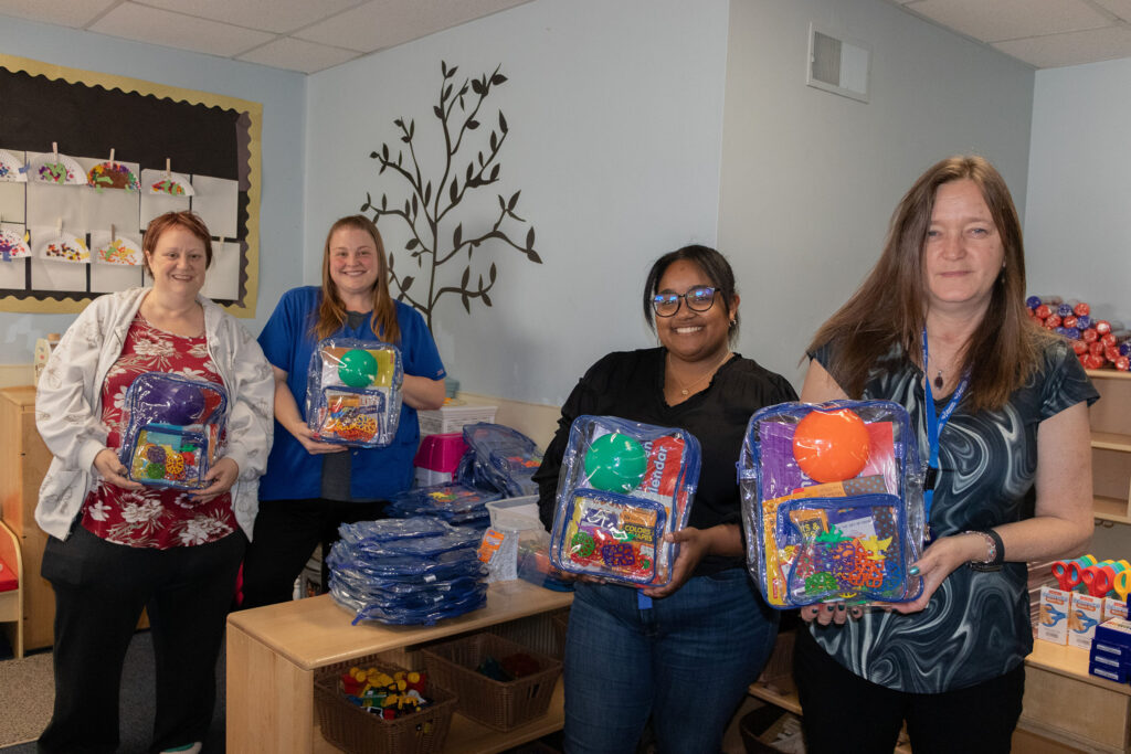 Luthercare for Kids Team Members assemble family engagement bags. The bags will be given to children to continue learning during the summer.